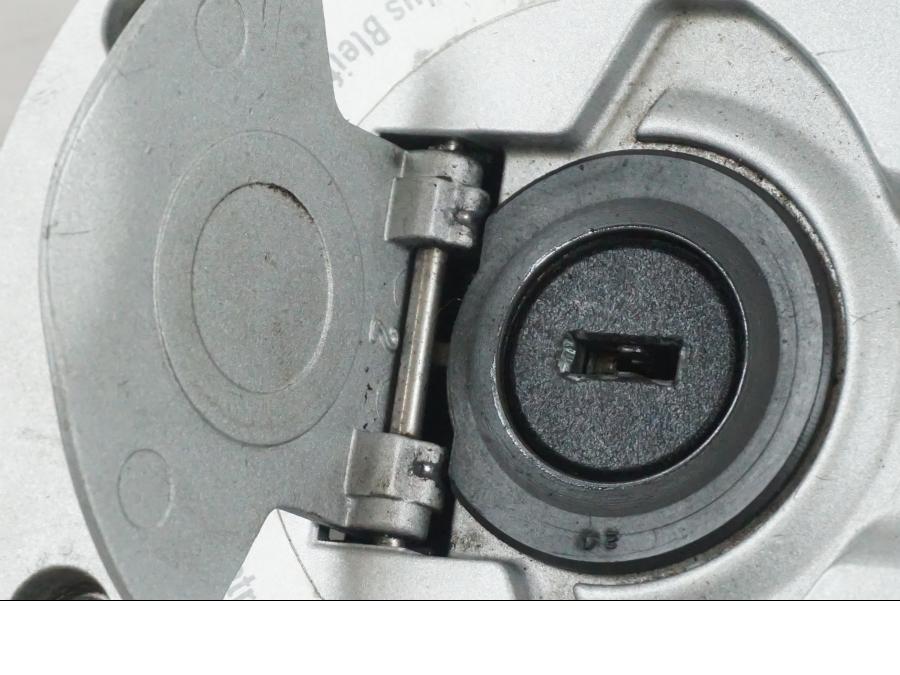 Snett uppifrån på <p>Låssats från BMW K 1200 R Sport 2007.</p>

<p>1st nyckel och en plastkopia, sadellås, tanklock, tändningslås (saknas plastbit vid en av kontakterna).</p> motorcykel.