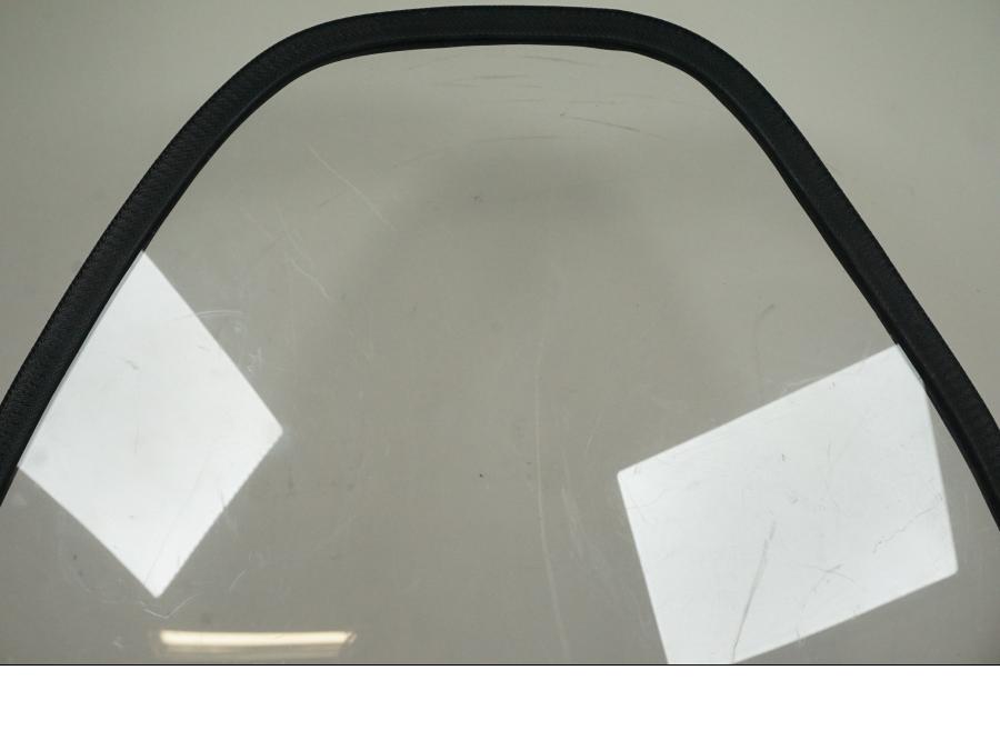 Baksidan på <p>Vindruta från Suzuki VZ 800 2000.</p>

<p>Fästen finns ej, skrapmärke på kromdetalj se bilder, rutfästena är original men vindrutan är hemmagjord. Ytliga repor finns på rutan se bilder.</p> motorcykel.