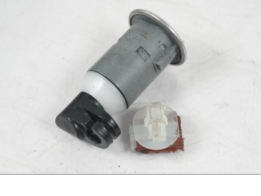 Baksidan på <p>Låssats från Honda CB 600 FA Hornet 2007.</p>

<p>Cdi, tändningslås, tanklock, sadellås, nyckel (svart).</p>

<p>Plasten för kontakt stycke skadat se bild.</p> motorcykel.