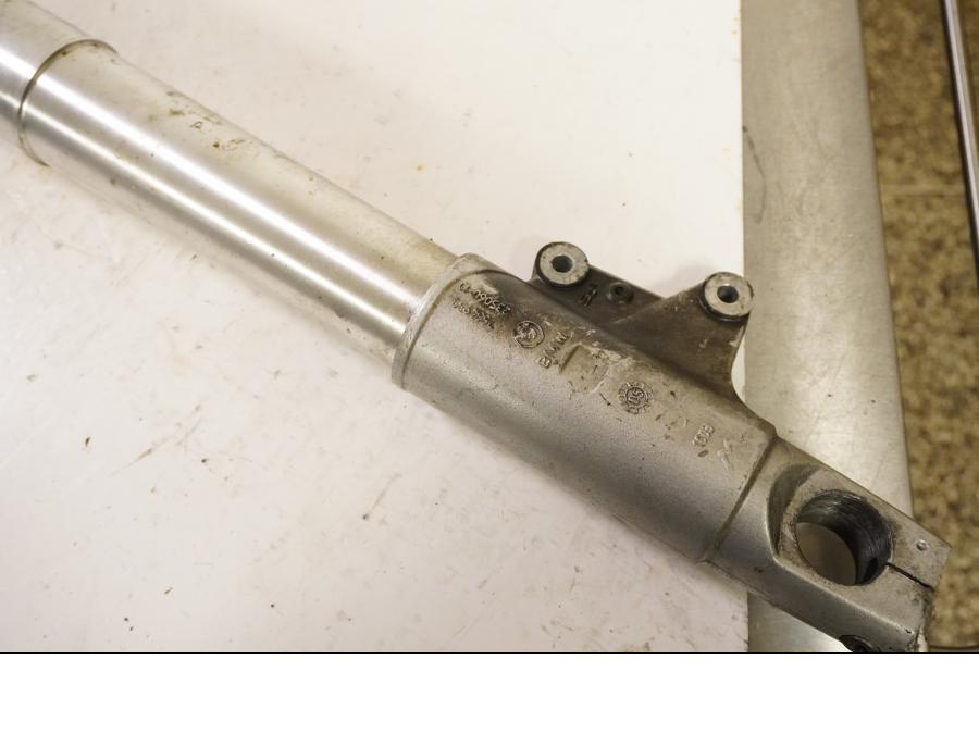 Snett uppifrån på <p>Gaffelben höger från BMW R 1200 GS 2006.</p>

<p>Små märken finns på nedre del av gaffelben.</p> motorcykel.