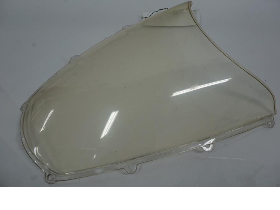 Extrabild1 på <p>Vindruta till Aprilia RSV 1000 2002.</p>

<p>Vindrutan är solblekt och har en gul "toning" sen vanlig transparant färg beroende på från vilken vinkel man kollar på den.</p>

<p>Ytliga repor / repor finns se bilder.</p> motorcykel.