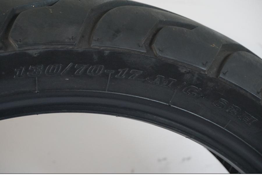 Snett uppifrån på <p>Begagnad däck av märket Dunlop och modell Arrowmax StreetSmart.</p>

<p>Märke från inbromsning se bild.</p>

<p>Dimension 130/70-17 M/C 62H. </p>

<p>Mönsterdjup ca: 5,10mm.</p>

<p>Mönsterdjup yttre kant ca: 5,50mm.</p>

<p>Tillv: vecka 40 år 2018.</p> moped.