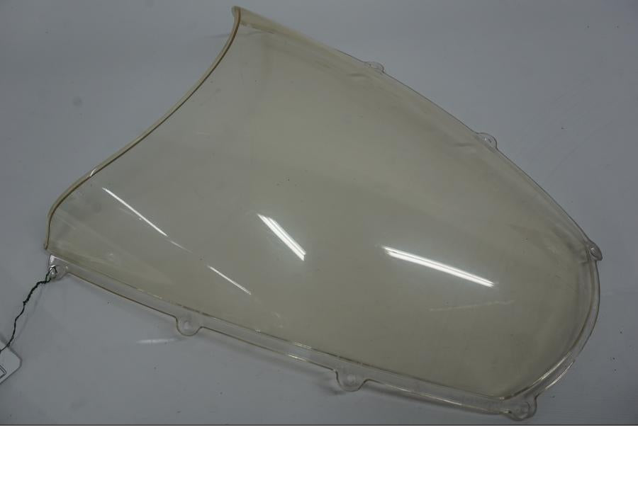 Baksidan på <p>Vindruta till Aprilia RSV 1000 2002.</p>

<p>Vindrutan är solblekt och har en gul "toning" sen vanlig transparant färg beroende på från vilken vinkel man kollar på den.</p>

<p>Ytliga repor / repor finns se bilder.</p> motorcykel.