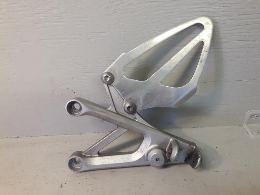 Framsidan på Fotpinnefäste från en Honda CBR 600 -1999 motorcykel.