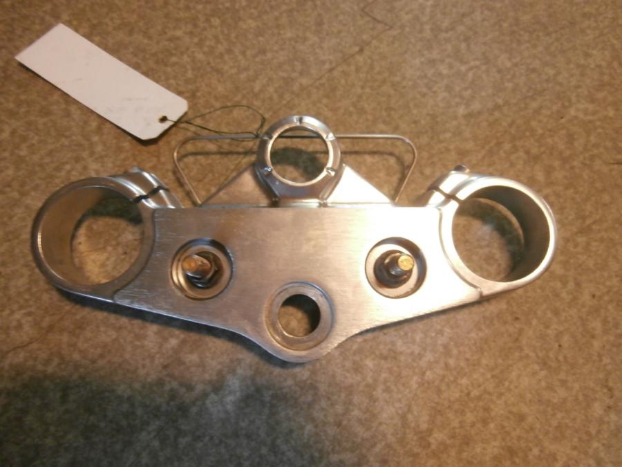 Framsidan på <p>Gaffelkrona övre från Triumph Speed Triple 2009.</p>

<p>Okej skick.</p> motorcykel.