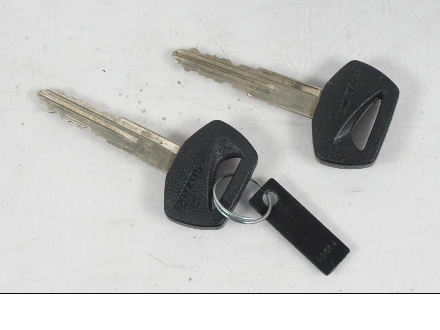 Baksidan på <p>Låssats från Suzuki VL 800 2004.</p>

<p>Tändningslås, tanklock, hjälmlås, lucklås och 2st nycklar.</p> motorcykel.