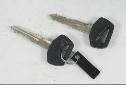 Baksidan på <p>Låssats från Suzuki VL 800 2004.</p>

<p>Tändningslås, tanklock, hjälmlås, lucklås och 2st nycklar.</p> motorcykel.