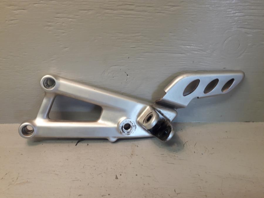 Framsidan på Fotpinnefäste från en Aprilia RS 125 -2017 motorcykel.