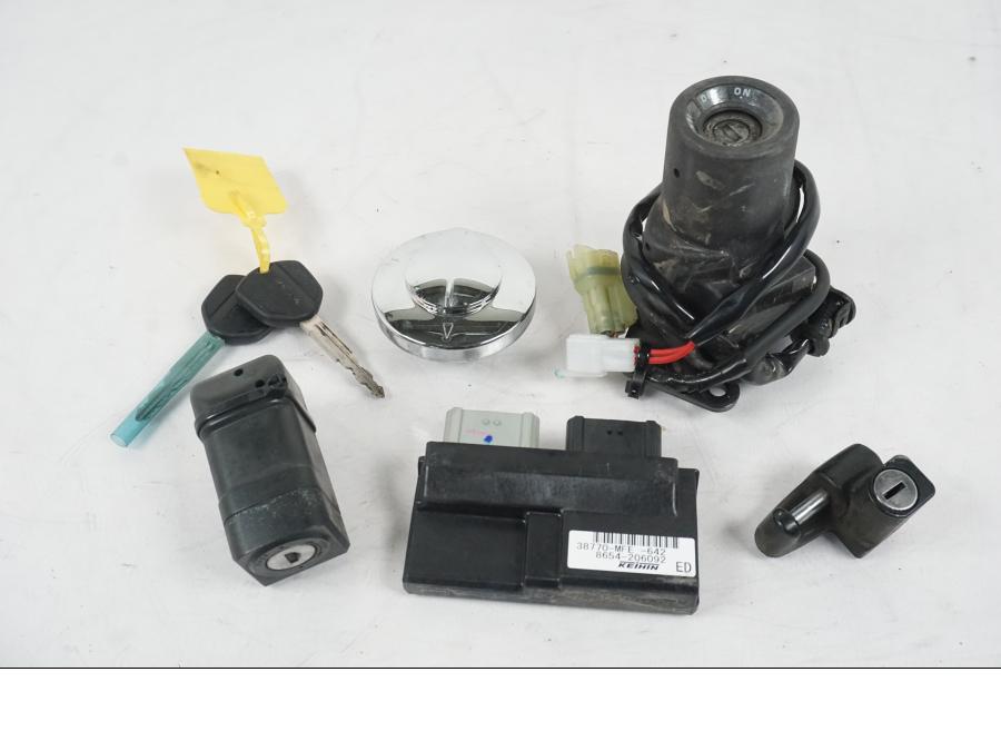 Framsidan på <p>Låssats från Honda VT 750 C2 2008.</p>

<p>Tändningslås, antenn, styrlås, tanklock, hjälmlås, 2st nycklar och CDI.</p> motorcykel.