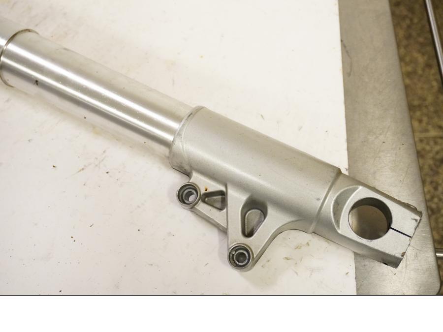 Baksidan på <p>Gaffelben höger från BMW R 1200 GS 2006.</p>

<p>Små märken finns på nedre del av gaffelben.</p> motorcykel.