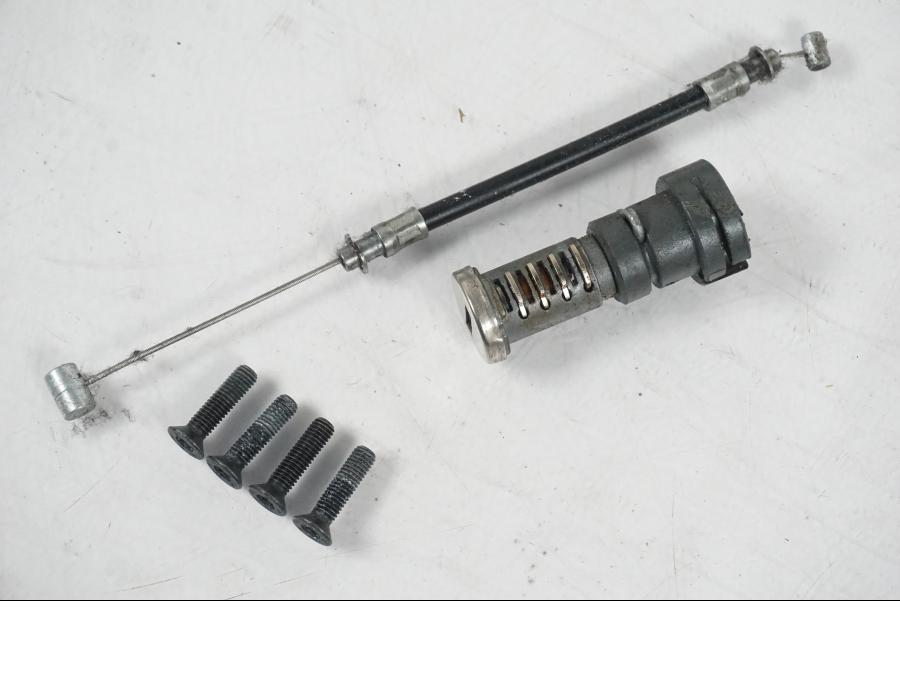 Snett uppifrån på <p>Låssats från BMW F 800 R 2010.</p>

<p>Tändningslås med antenn lite ful i ena fästet, tanklock, sadellås och 1st nyckel.</p> motorcykel.