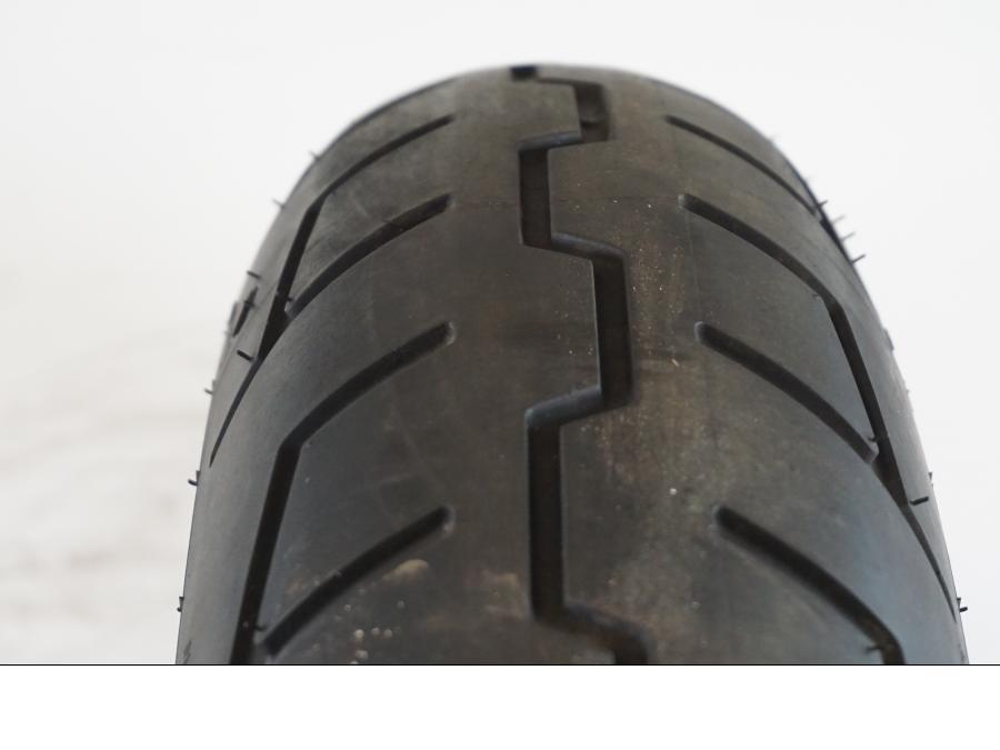 Snett nerifrån på <p>Begagnad däck av märket Michelin och modell Scorcher "31" Harley Davidson.</p>

<p>Dimension 130/70-18.63H </p>

<p>Mönsterdjup ca.4mm 70%</p>

<p>Tillv.03/2022</p> moped.