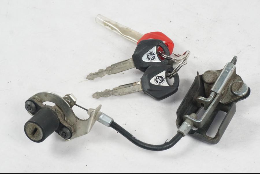 Snett nerifrån på <p>Låssats från Yamaha XT 1200 Z ABS 2011.</p>

<p>Cdi, tändningslås, antenn, tanklock, sadellås, toppboxlås och 3st nycklar. Finns en skada på sadellåsmekanismens skyddsgummi se bild.</p> motorcykel.