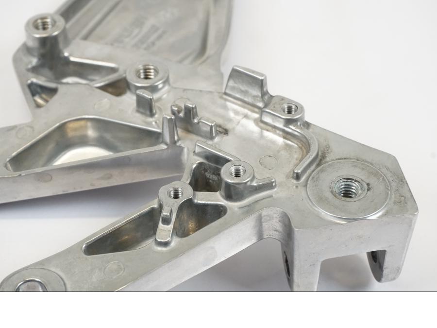 Vänster sida på Fotpinnefäste från en Triumph Trident -2021 motorcykel.