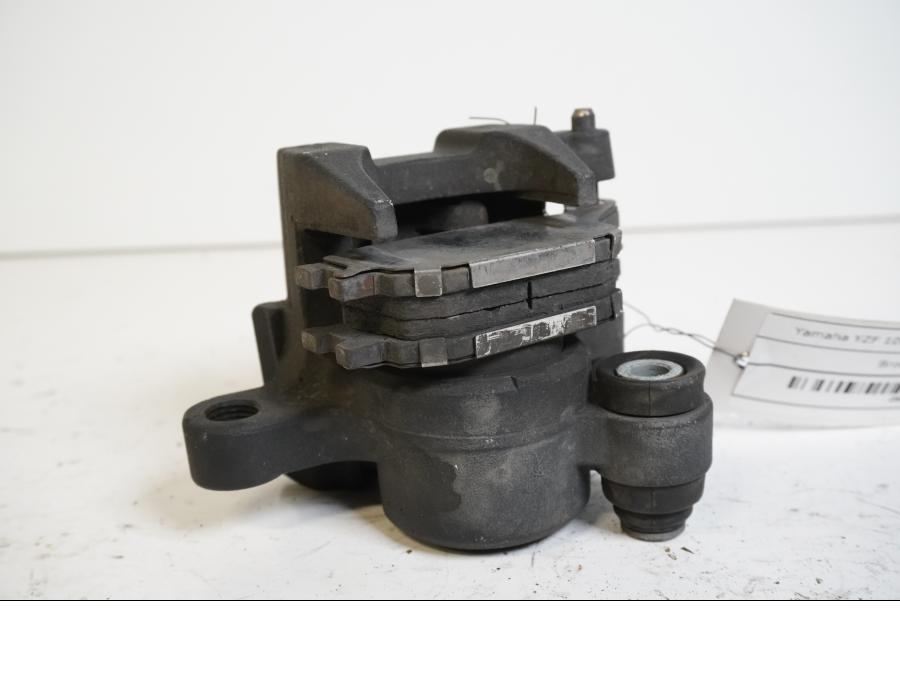 Höger sida på <p>Bromsok bak från Yamaha YZF 1000 R1 2005.</p>

<p>Ett kolvs ok. Nissin.</p> motorcykel.