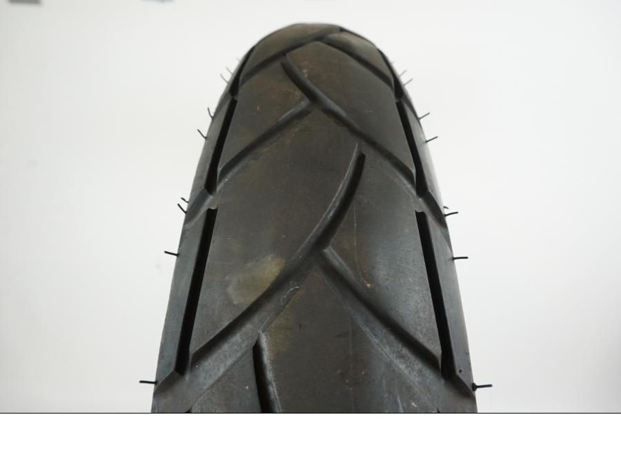 Baksidan på <p>Bikepart-däck, modell utan specifik årsmodell och med okänt skick, erbjuder standardegenskaper för cyklar. Däckets exakta prestanda och användningshistorik är inte specificerade, vilket innebär att eventuella defekter eller slitage ej har bedömts.</p> motorcykel.