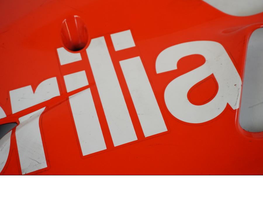 Snett uppifrån på <p>Magkåpa vänster från Aprilia RSV 1000 R Factory 2008.</p>

<p>Repor, slitage av lack se bilder.</p> motorcykel.