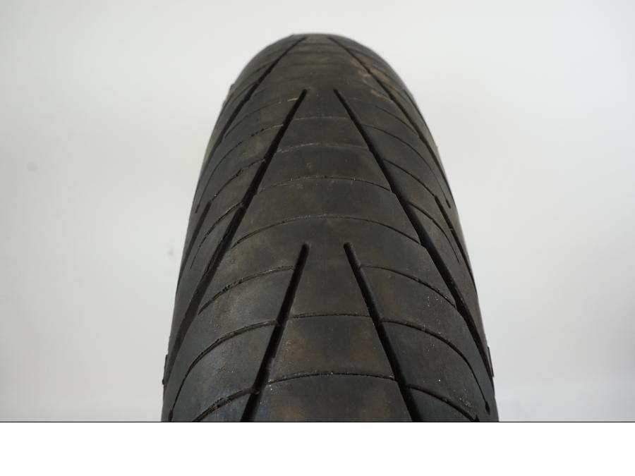 Baksidan på <p>Däck: Michelin Pilot Road 3.</p>

<p>Dimension: 120/70-ZR17 M/C (58W).</p>

<p>Tillv. 5015.</p>

<p>Mönsterdjup: ca. 70 %.</p> motorcykel.