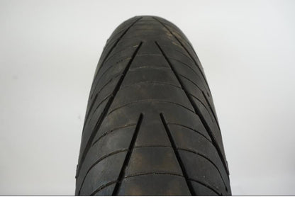 Baksidan på <p>Däck: Michelin Pilot Road 3.</p>

<p>Dimension: 120/70-ZR17 M/C (58W).</p>

<p>Tillv. 5015.</p>

<p>Mönsterdjup: ca. 70 %.</p> motorcykel.