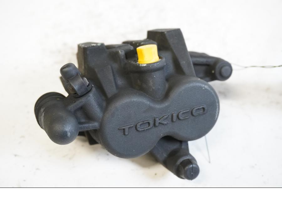 Framsidan på <p>Bromsok vänster fram från Kawasaki ER-6N ABS 2011.</p>

<p>Tokico. Två kolvs ok. Okej skick.</p> motorcykel.