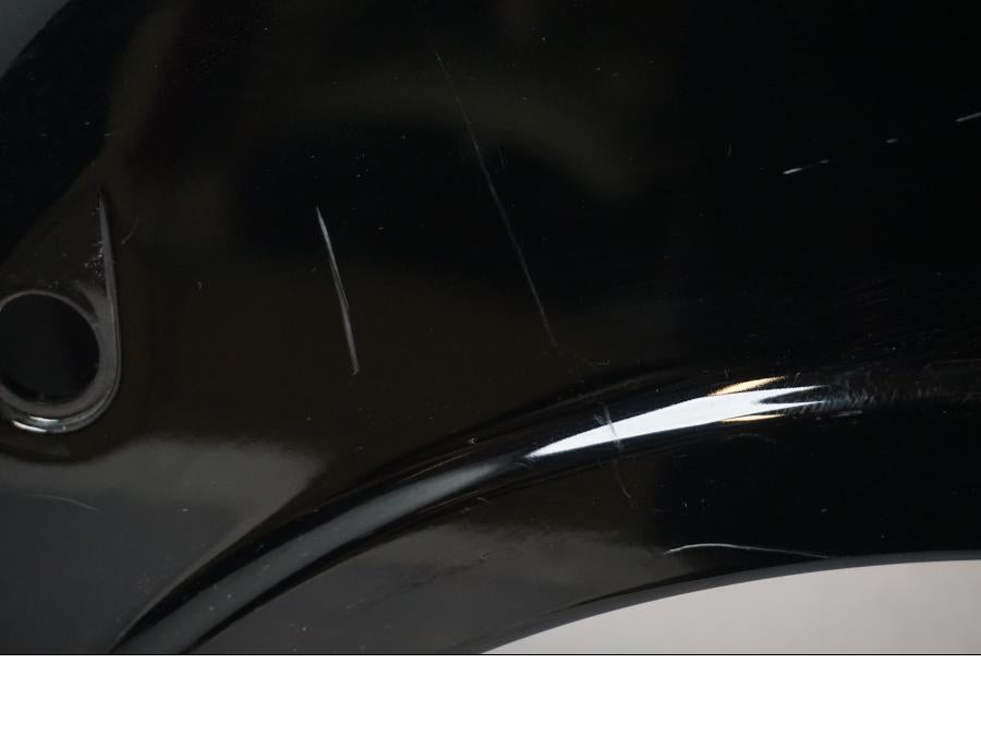 Vänster sida på <p>Bakskärm från Suzuki VL 800 2007.</p>

<p>Två sprickor i bakkant, repor och mindre slitage av lack finns se bilder.</p> motorcykel.