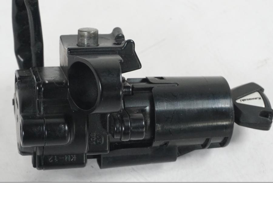 Baksidan på <p>Låssats från Kawasaki Z 900 ABS 2017.</p>

<p>Tändningslås, 1st nyckel, tanklock, sadellås, ignition immobilisor och CDI/ECU.</p> motorcykel.