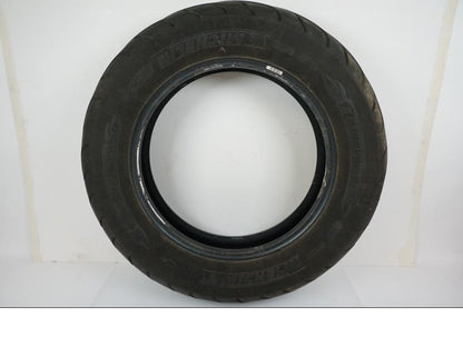 Framsidan på <p>Däck: Michelin Commander II.</p>

<p>Dimension: 150/90B15 M/C 74H.</p>

<p>Tillv. 4715.</p>

<p>Mönsterdjup: ca. 80 %, något snedslitet.</p> motorcykel.