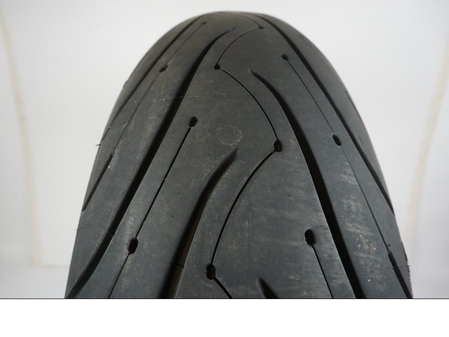 Baksidan på <p>Däck: Michelin Pilot Road 3.</p>

<p>Dimension: 180/55-ZR17 M/C (73W).</p>

<p>Tillv. 1215.</p>

<p>Mönsterdjup: ca. 70 %, lätt plattslitet.</p> motorcykel.