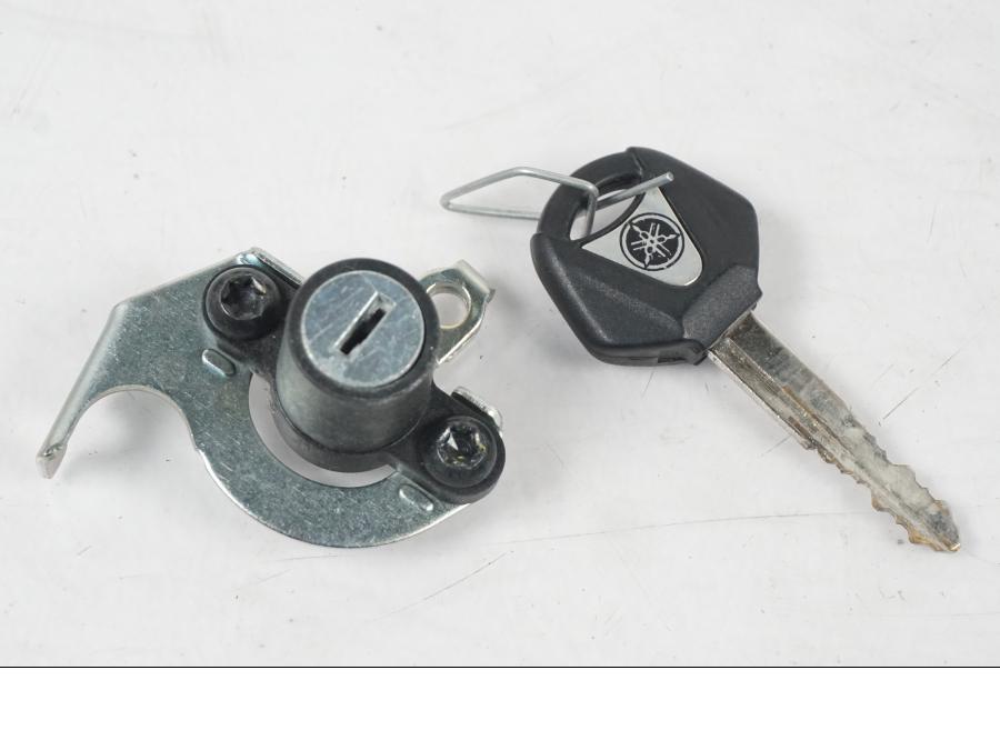 Baksidan på <p>Låssats från Yamaha MT-07 2014.</p>

<p>1st nyckel (svart), tändningslås, antenn, sadellås, CDI och tanklock.</p> motorcykel.