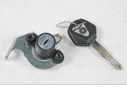 Baksidan på <p>Låssats från Yamaha MT-07 2014.</p>

<p>1st nyckel (svart), tändningslås, antenn, sadellås, CDI och tanklock.</p> motorcykel.