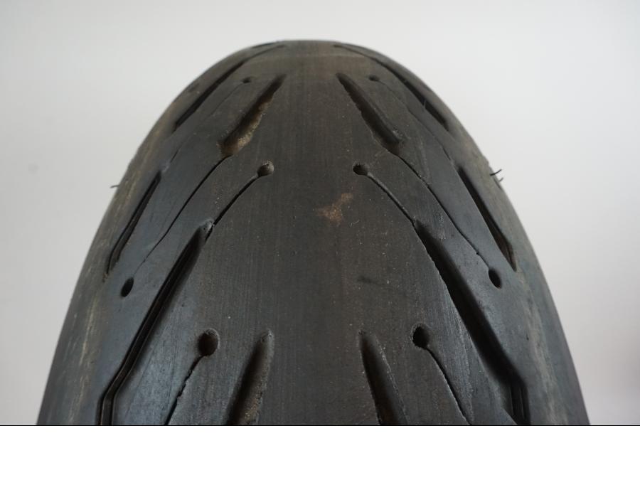 Baksidan på <p>Däck: Michelin Road 5 2CT. </p>

<p>Dimension: 190/50-ZR17 M/C (73W) Tillv 2818. Mönsterdjup: Ytterkant ca 6.43 mm. Mitten ca 4.45 mm.</p> motorcykel.