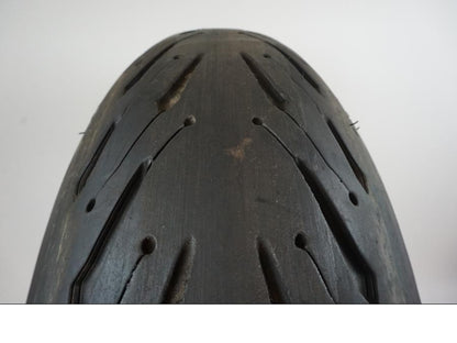 Baksidan på <p>Däck: Michelin Road 5 2CT. </p>

<p>Dimension: 190/50-ZR17 M/C (73W) Tillv 2818. Mönsterdjup: Ytterkant ca 6.43 mm. Mitten ca 4.45 mm.</p> motorcykel.
