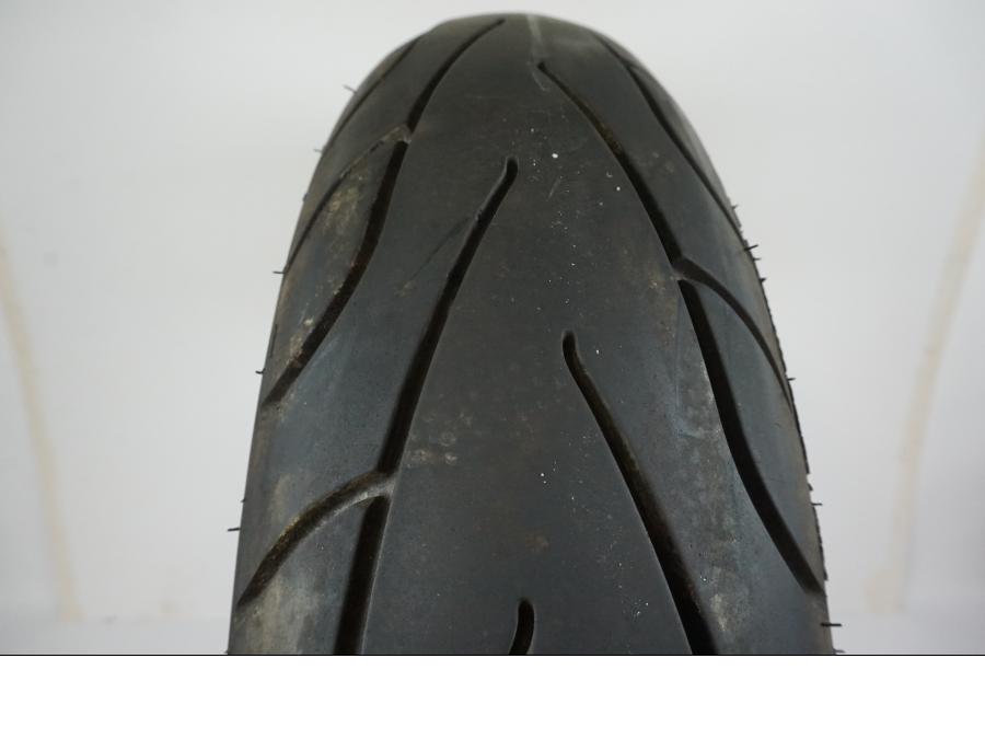 Baksidan på <p>Däck: Michelin Commander II.</p>

<p>Dimension: 150/90B15 M/C 74H.</p>

<p>Tillv. 4715.</p>

<p>Mönsterdjup: ca. 80 %, något snedslitet.</p> motorcykel.