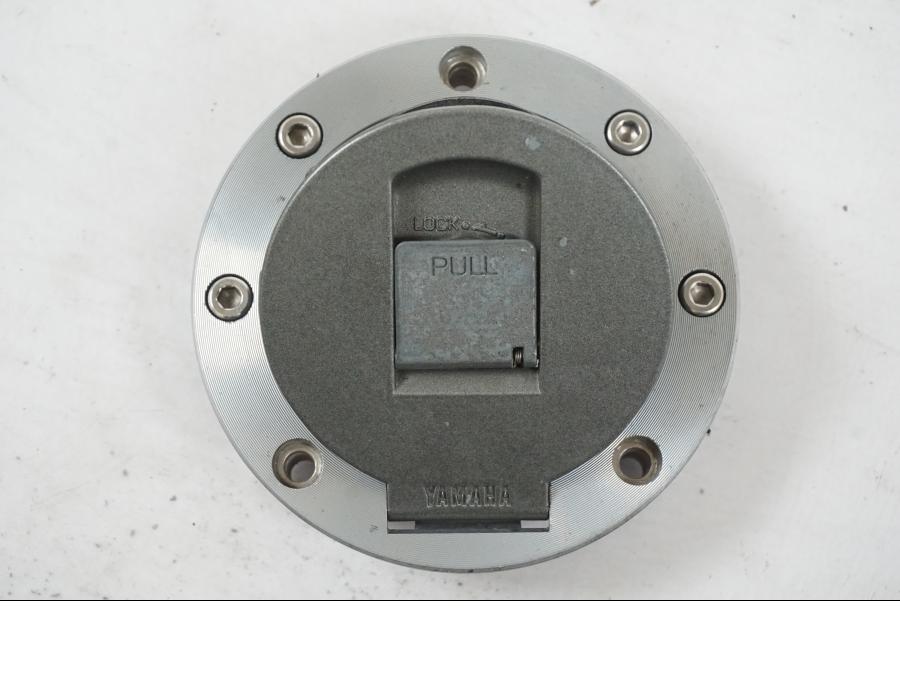 Höger sida på <p>Låssats från Yamaha FJ 1200 1986.</p>

<p>Tändningslås. Tanklock, 1st nyckel.</p>

<p>Repor och slitage av lack på tändningslåset samt att gummiskyddet för vajrarna har ett mindre hål se bilder.</p> motorcykel.