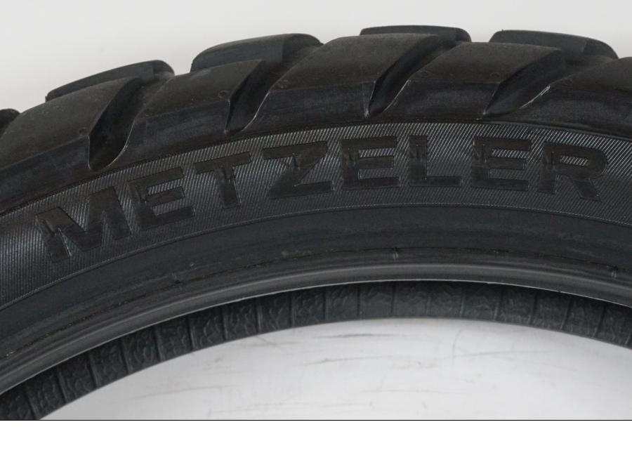 Baksidan på <p>Begagnad däck av märket Metzeler.</p>

<p>Modell Karoo 3.</p>

<p>Dimension 120/70 R 19 M/C 60T M S. </p>

<p>Mönsterdjup ca: 40% kvar.</p>

<p>Tillv: Vecka 4, år 2019.</p> moped.