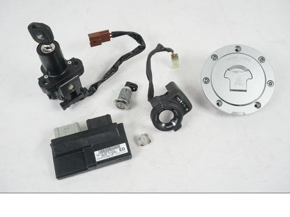 Framsidan på <p>Låssats från Honda CB 600 FA Hornet 2007.</p>

<p>Cdi, tändningslås, tanklock, sadellås, nyckel (svart).</p>

<p>Plasten för kontakt stycke skadat se bild.</p> motorcykel.