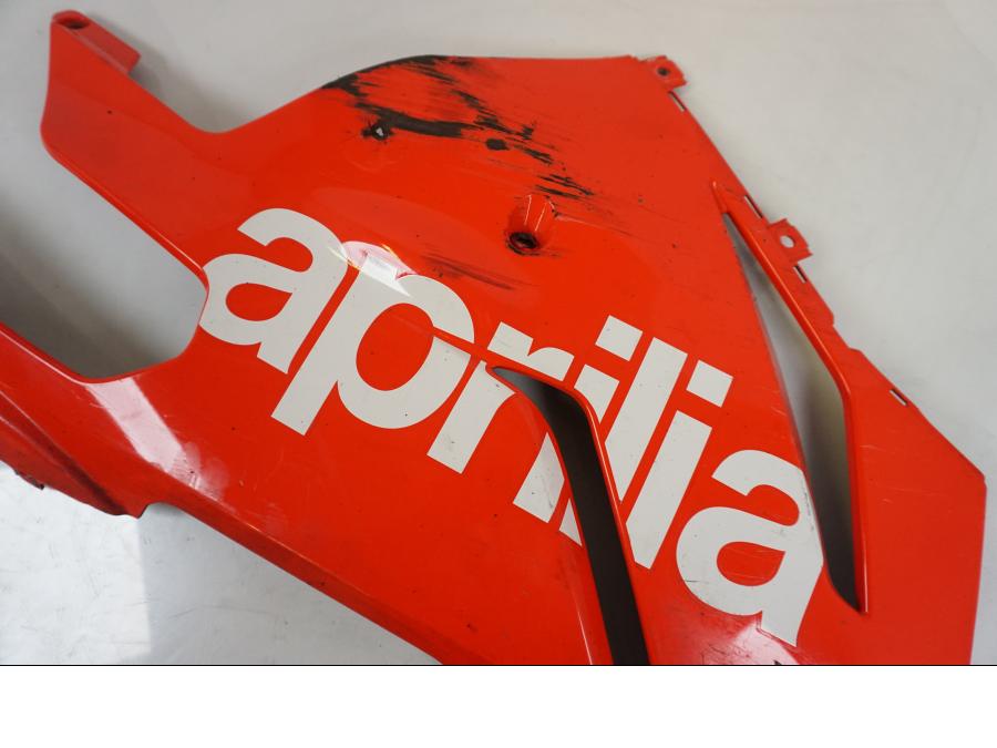 Snett uppifrån på <p>Magkåpa höger från Aprilia RSV 1000 R Factory 2008.</p>

<p>Skrapmärken, ett mindre hål, mindre spricka, repor och</p>

<p>lacksläpp se bilder.</p> motorcykel.