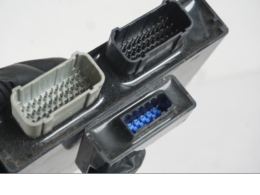 Snett nerifrån på <p>Låssats från Kawasaki Z 900 ABS 2017.</p>

<p>Tändningslås, 1st nyckel, tanklock, sadellås, ignition immobilisor och CDI/ECU.</p> motorcykel.