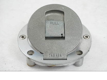 Vänster sida på <p>Låssats från Yamaha FJ 1200 1986.</p>

<p>Tändningslås. Tanklock, 1st nyckel.</p>

<p>Repor och slitage av lack på tändningslåset samt att gummiskyddet för vajrarna har ett mindre hål se bilder.</p> motorcykel.