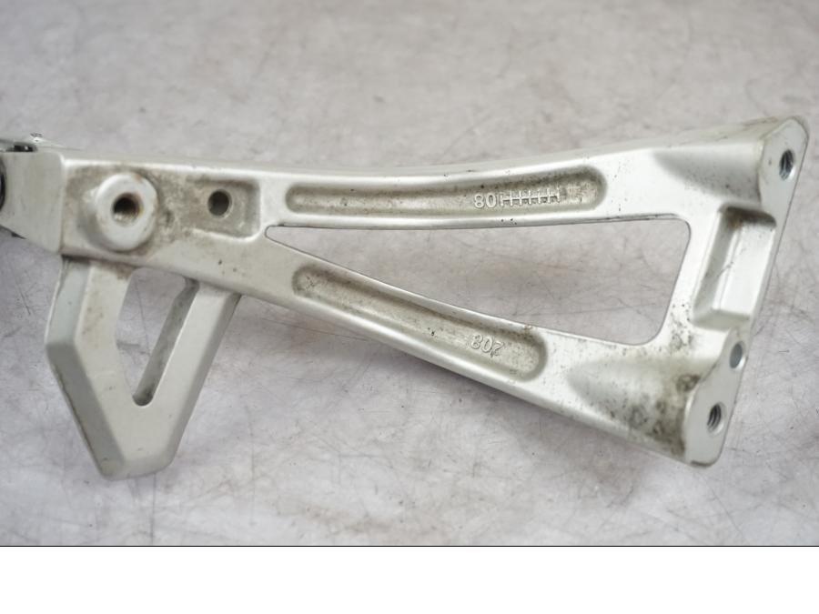 Vänster sida på Fotpinnefäste från en Triumph Tiger -2009 motorcykel.