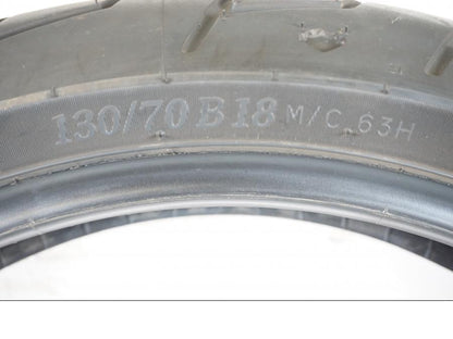 Vänster sida på <p>Begagnad däck av märket Michelin och modell Scorcher "31" Harley Davidson.</p>

<p>Dimension 130/70-18.63H </p>

<p>Mönsterdjup ca.4mm 70%</p>

<p>Tillv.03/2022</p> moped.