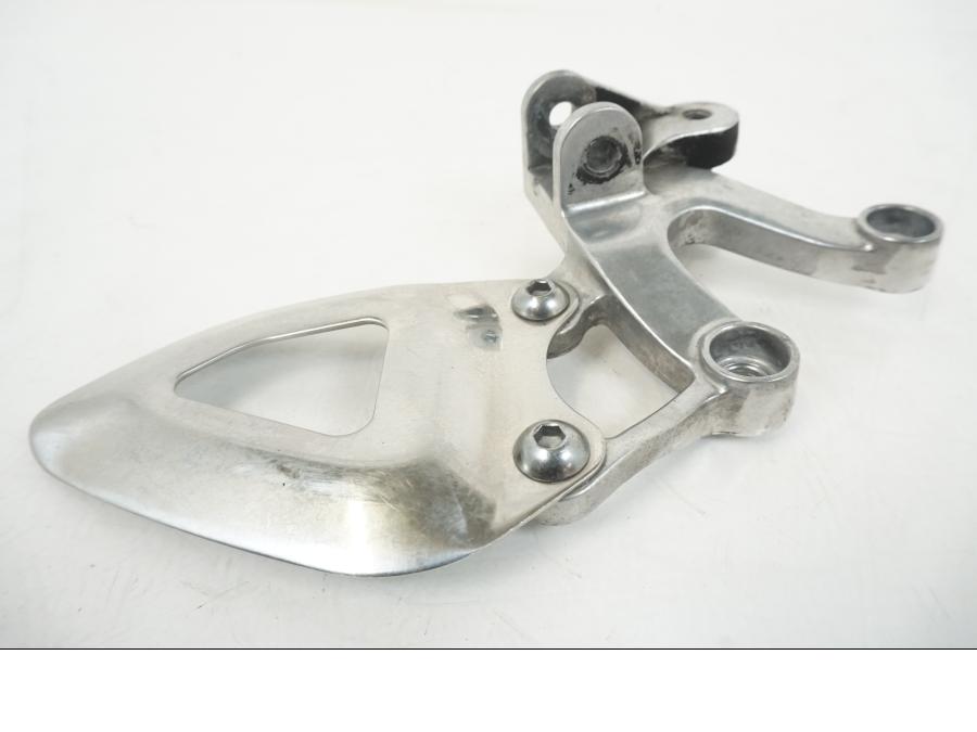 Vänster sida på Fotpinnefäste från en Triumph Speed Triple -2009 motorcykel.