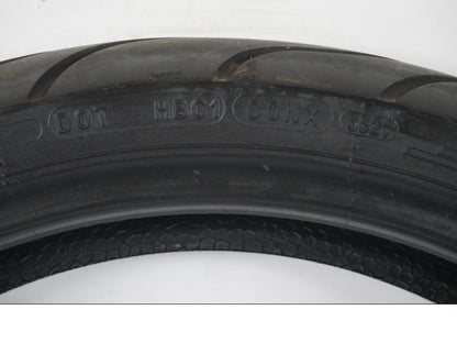 Snett uppifrån på <p>Begagnad däck av märket Michelin och modell Pilot Power 2CT.</p>

<p>Dimension 110/70ZR17 M/C (54W). </p>

<p>Mönsterdjup ca: 3,00mm.</p>

<p>Mönsterdjup yttre kant ca: 3,75mm.</p>

<p>Tillv: vecka 33 år 2021.</p> moped.