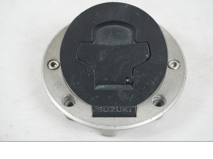 Vänster sida på <p>Låssats från Suzuki TL 1000 S 1997.</p>

<p>Tändningslås, tanklock, sadellås och 1st nyckel.</p>

<p>Repor finns på tanklocket, slitage av lack på tändningslåset även att gummi skyddet för kabel har ett hål se bild.</p> motorcykel.