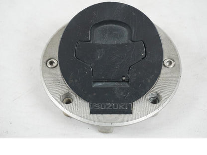 Vänster sida på <p>Låssats från Suzuki TL 1000 S 1997.</p>

<p>Tändningslås, tanklock, sadellås och 1st nyckel.</p>

<p>Repor finns på tanklocket, slitage av lack på tändningslåset även att gummi skyddet för kabel har ett hål se bild.</p> motorcykel.