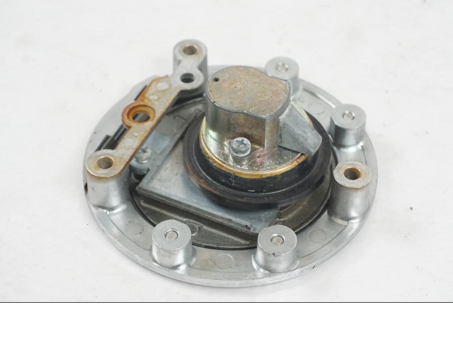 Snett nerifrån på <p>Låssats från Yamaha FJ 1200 1986.</p>

<p>Tändningslås. Tanklock, 1st nyckel.</p>

<p>Repor och slitage av lack på tändningslåset samt att gummiskyddet för vajrarna har ett mindre hål se bilder.</p> motorcykel.