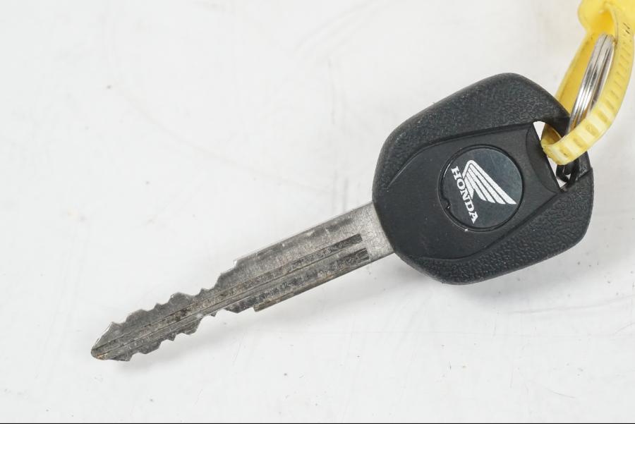 Baksidan på <p>Låssats från Honda CB 500 F 2013.</p>

<p>Tändningslås, antenn, tanklock, sadellås, CDI/ECU och 1st nyckel.</p> motorcykel.