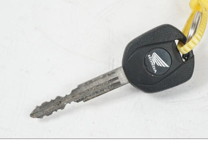 Baksidan på <p>Låssats från Honda CB 500 F 2013.</p>

<p>Tändningslås, antenn, tanklock, sadellås, CDI/ECU och 1st nyckel.</p> motorcykel.