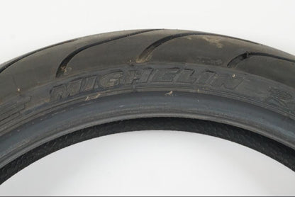 Snett uppifrån på <p>Begagnad däck av märket Michelin och modell Pilot Power 2CT.</p>

<p>Dimension 120/65-17.</p>

<p>Mönsterdjup ca: 60% (3,50mm).</p>

<p>Tillv 1022.</p> moped.