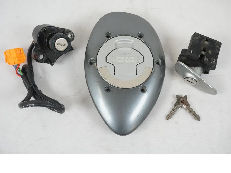 Framsidan på <p>Låssats från BMW R 1200 C 2002.</p>

<p>Tändningslås, tanklock, ett väsklås, skador finns och 2st nycklar. Lacksläpp på tändningslåset se bild.</p> motorcykel.